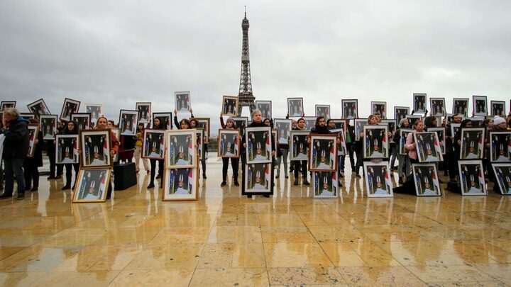 100 portraits de Macron brandis à l'envers devant la Tour Eiffel